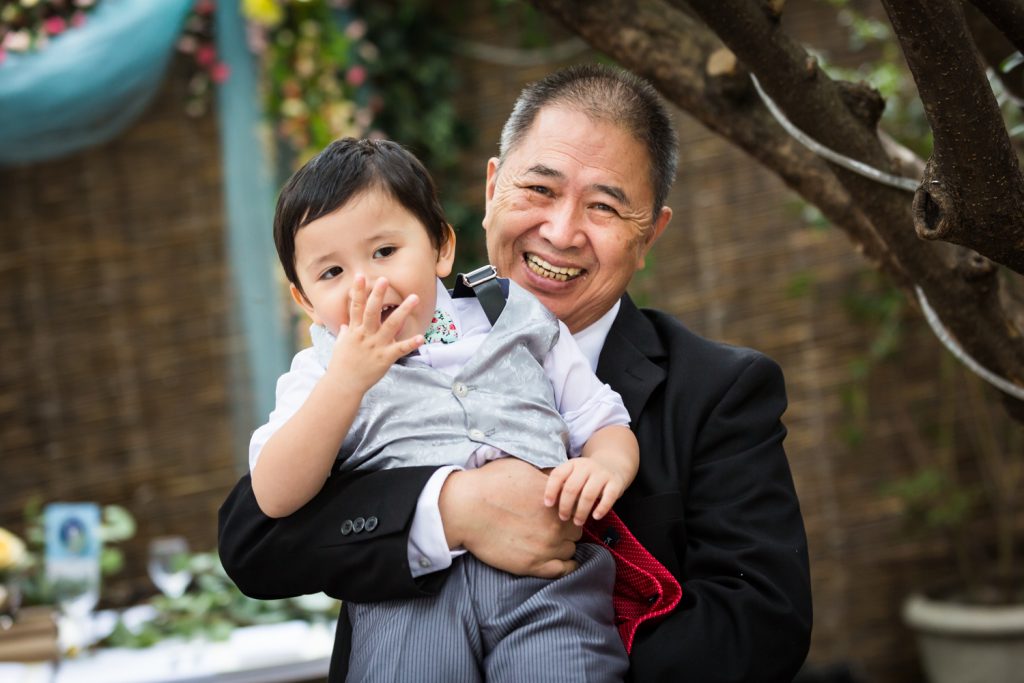 Grandfather holding up grandson for an article on the pros and cons of a restaurant wedding