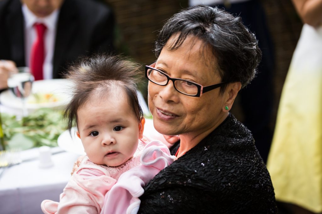 Grandmother holding baby girl for an article on the pros and cons of a restaurant wedding