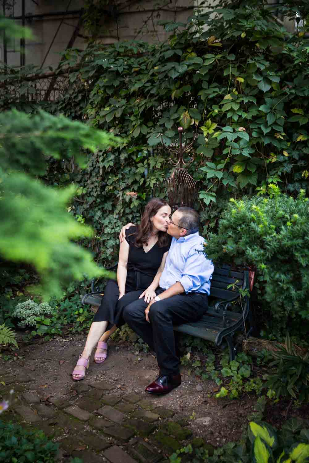 Older couple kissing in middle of garden at a community garden family portrait session