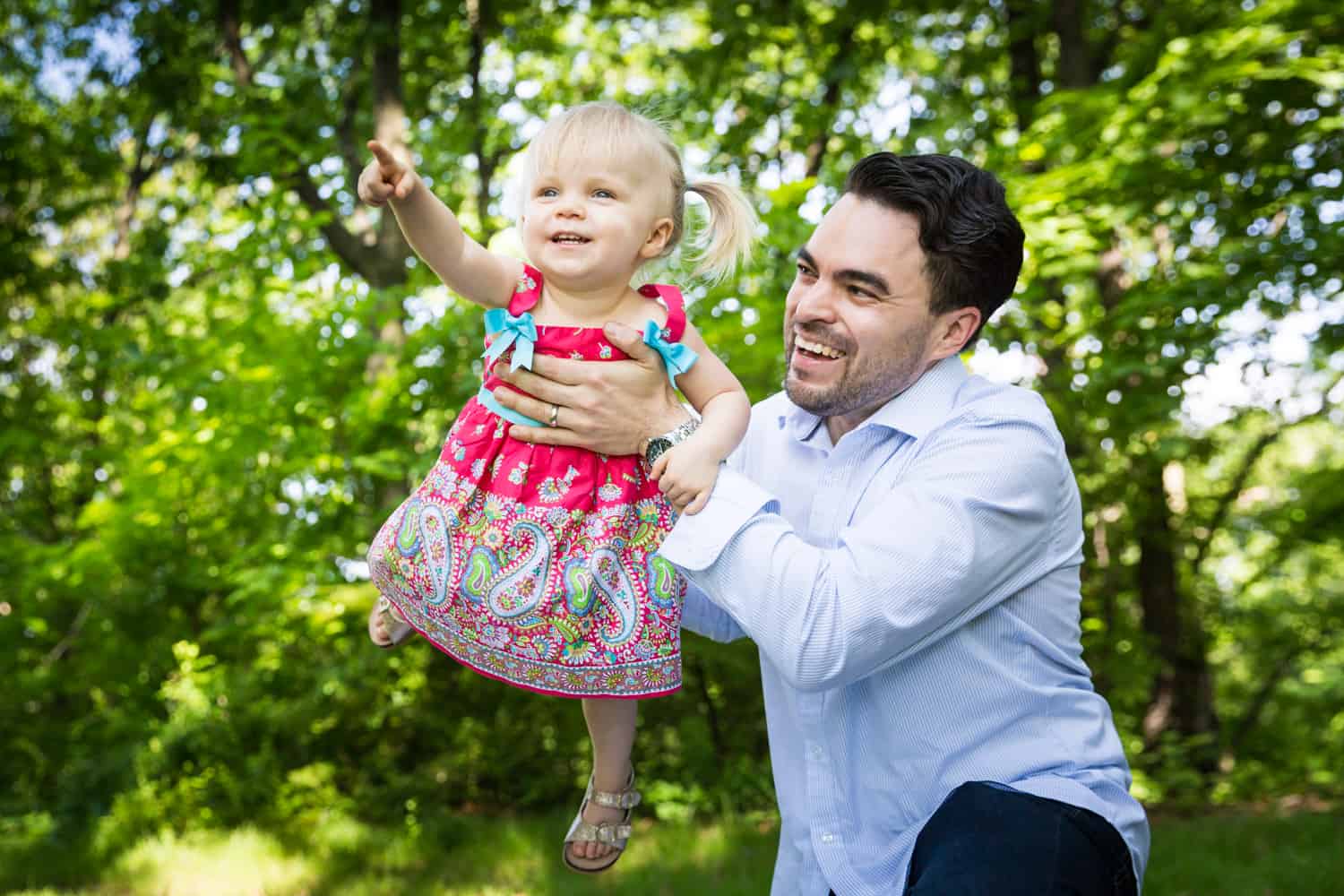 Father playing airplane with little girl during a Forest Park family photo shoot