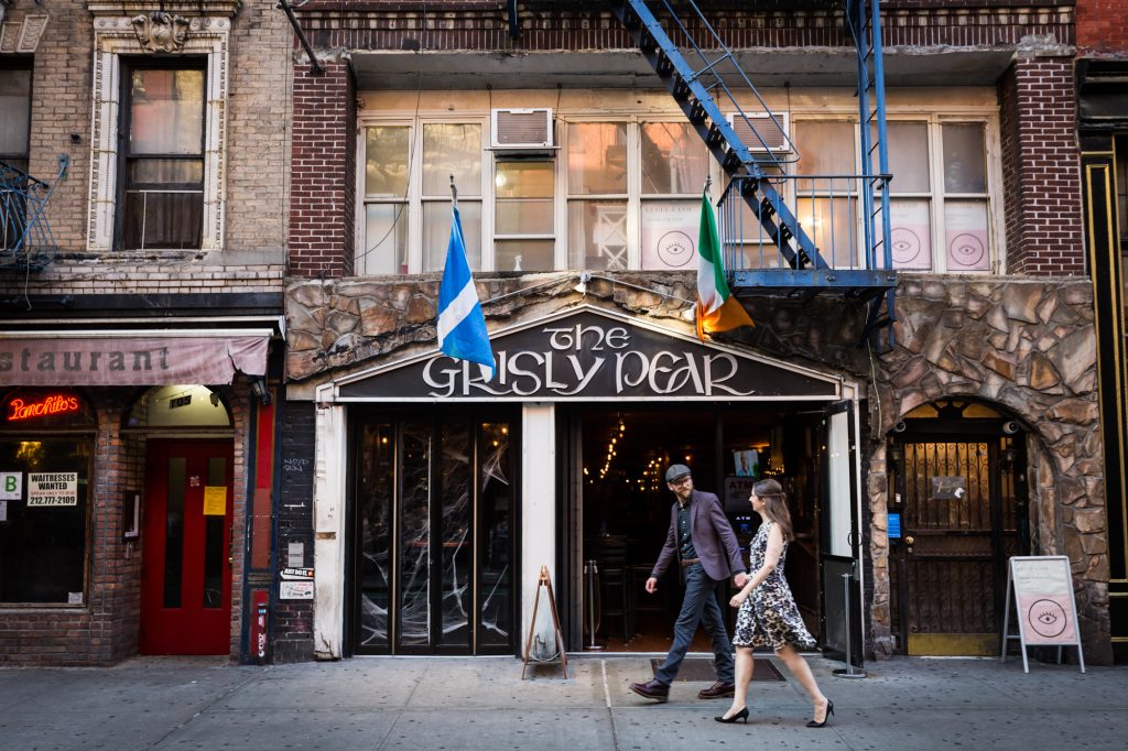 Couple walking past Grisley Pear for a Greenwich Village engagement portrait