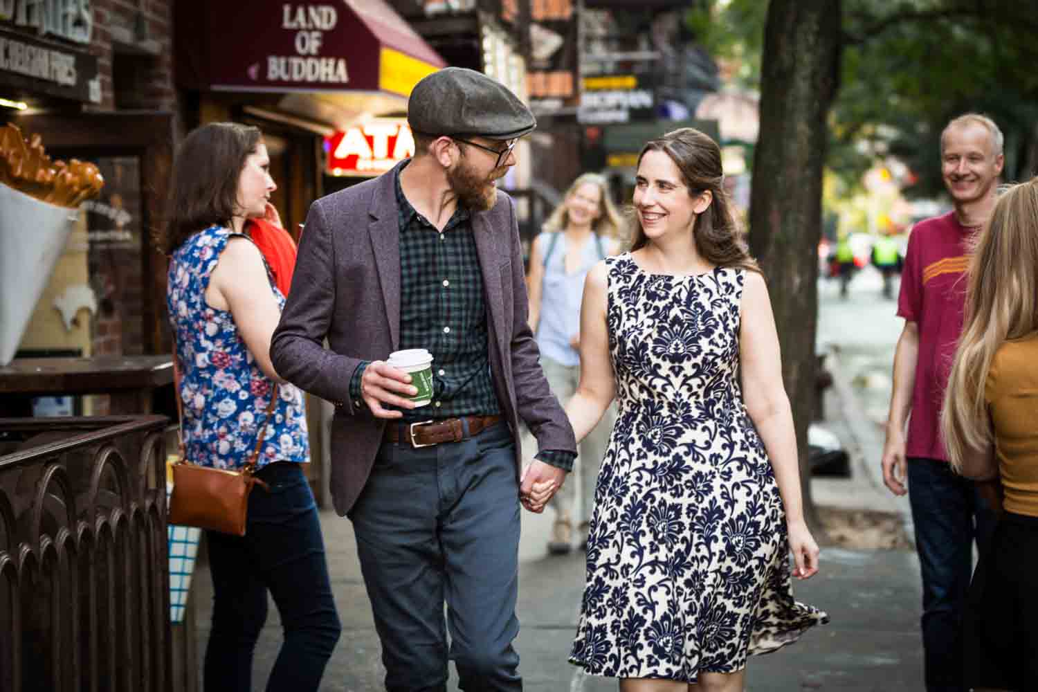Couple holding hands and walking on MacDouglas Street for a Greenwich Village engagement portrait