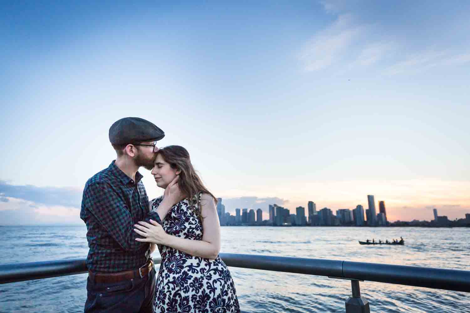 Man kissing woman's head in front of Hudson River