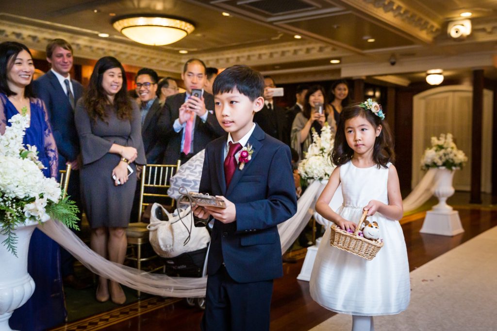 Little flower girl and ring bearer walking down aisle at a Westbury Manor wedding