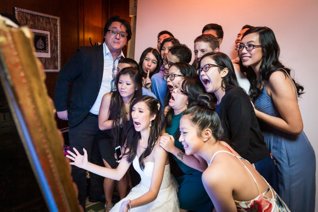 Bride and large group of guests taking photo at photo booth at a Westbury Manor wedding