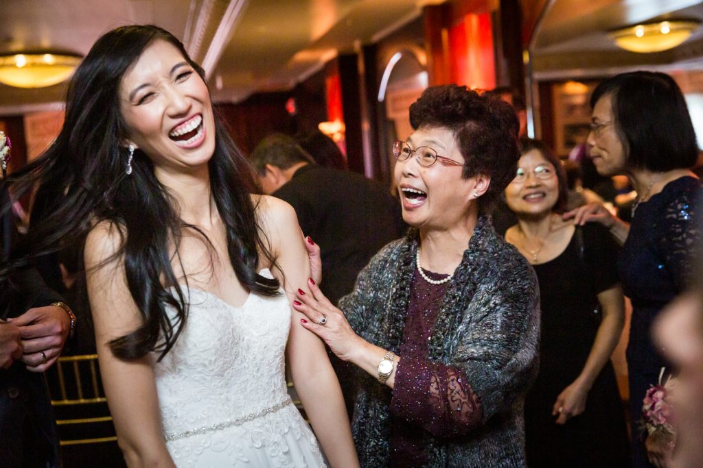 Bride and older woman laughing at reception at a Westbury Manor wedding