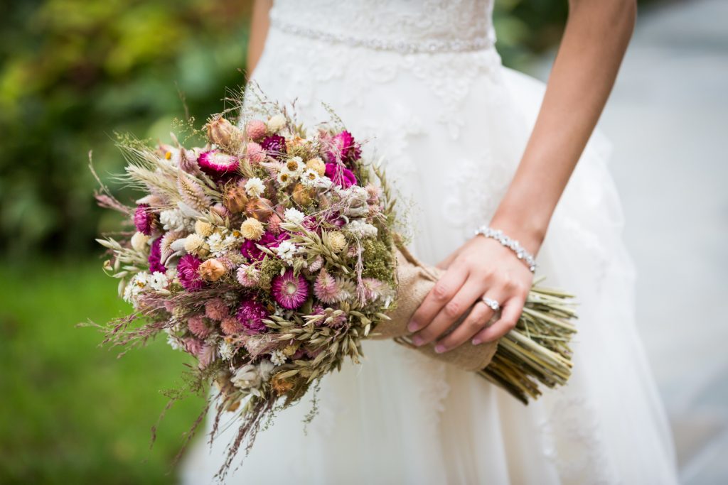 Close up on bride holding dried flower bouquet at a Westbury Manor wedding