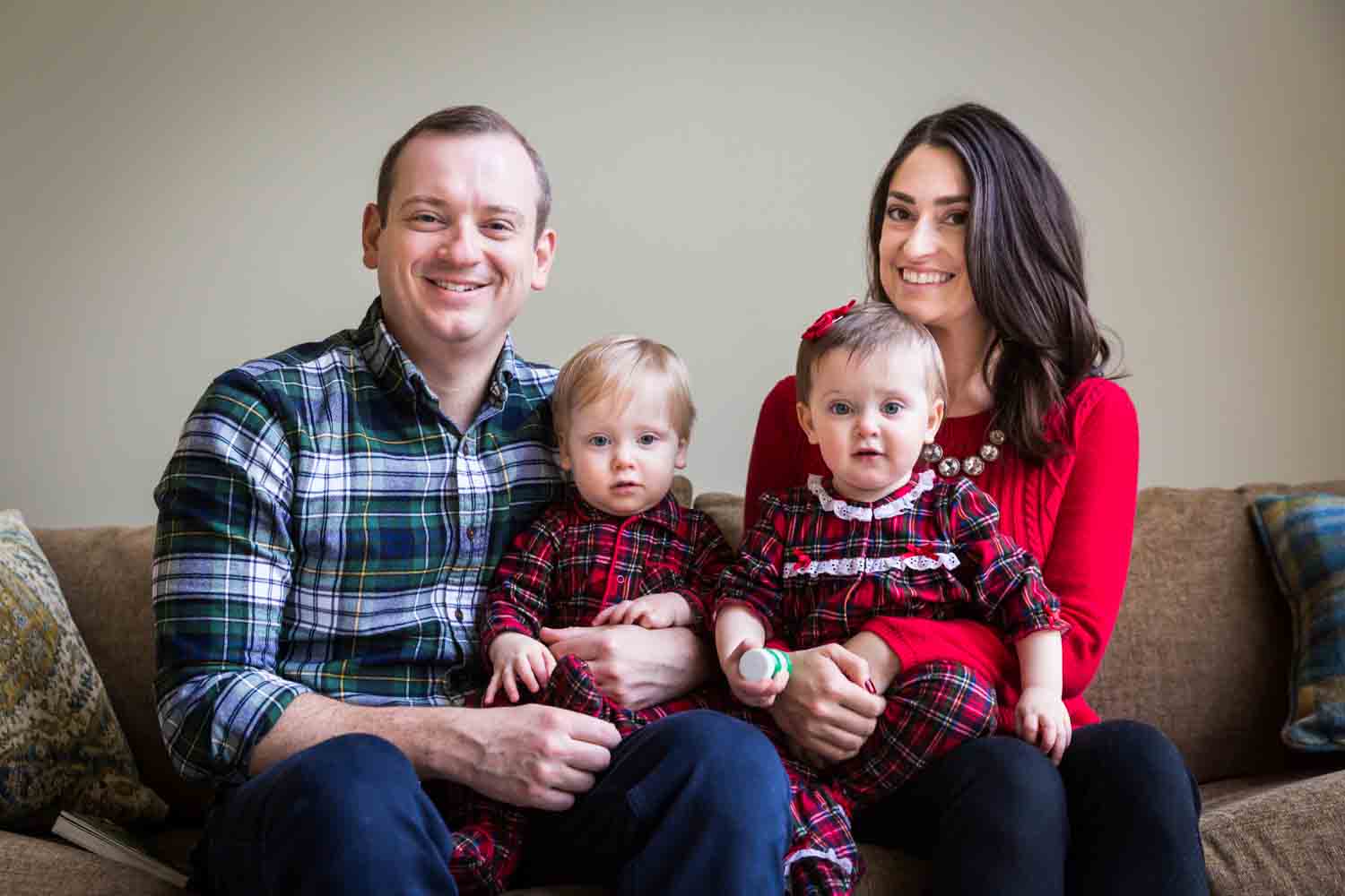 Family portrait on couch of father, mother, and two kids for article on how to get your kids to look into the camera