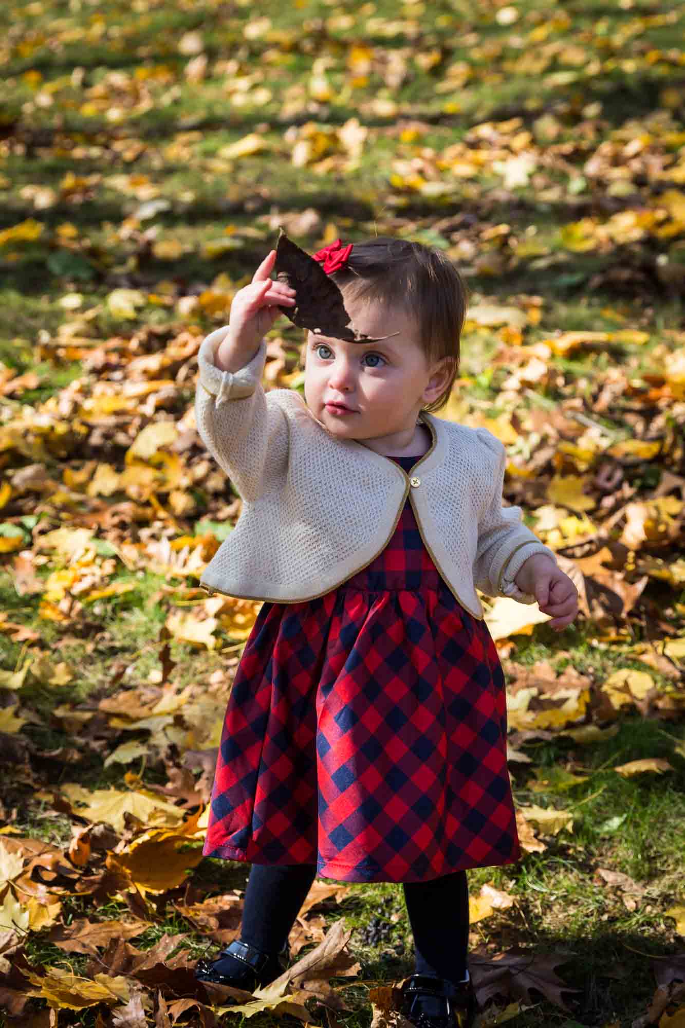 Child with leaf for article on how to get your kids to look into the camera