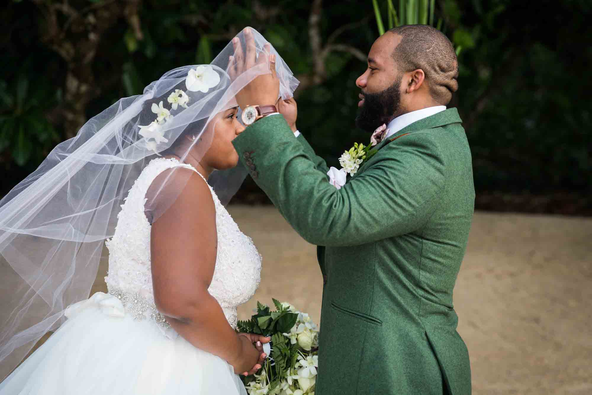 Groom lifting bride's veil for an article on destination wedding planning tips