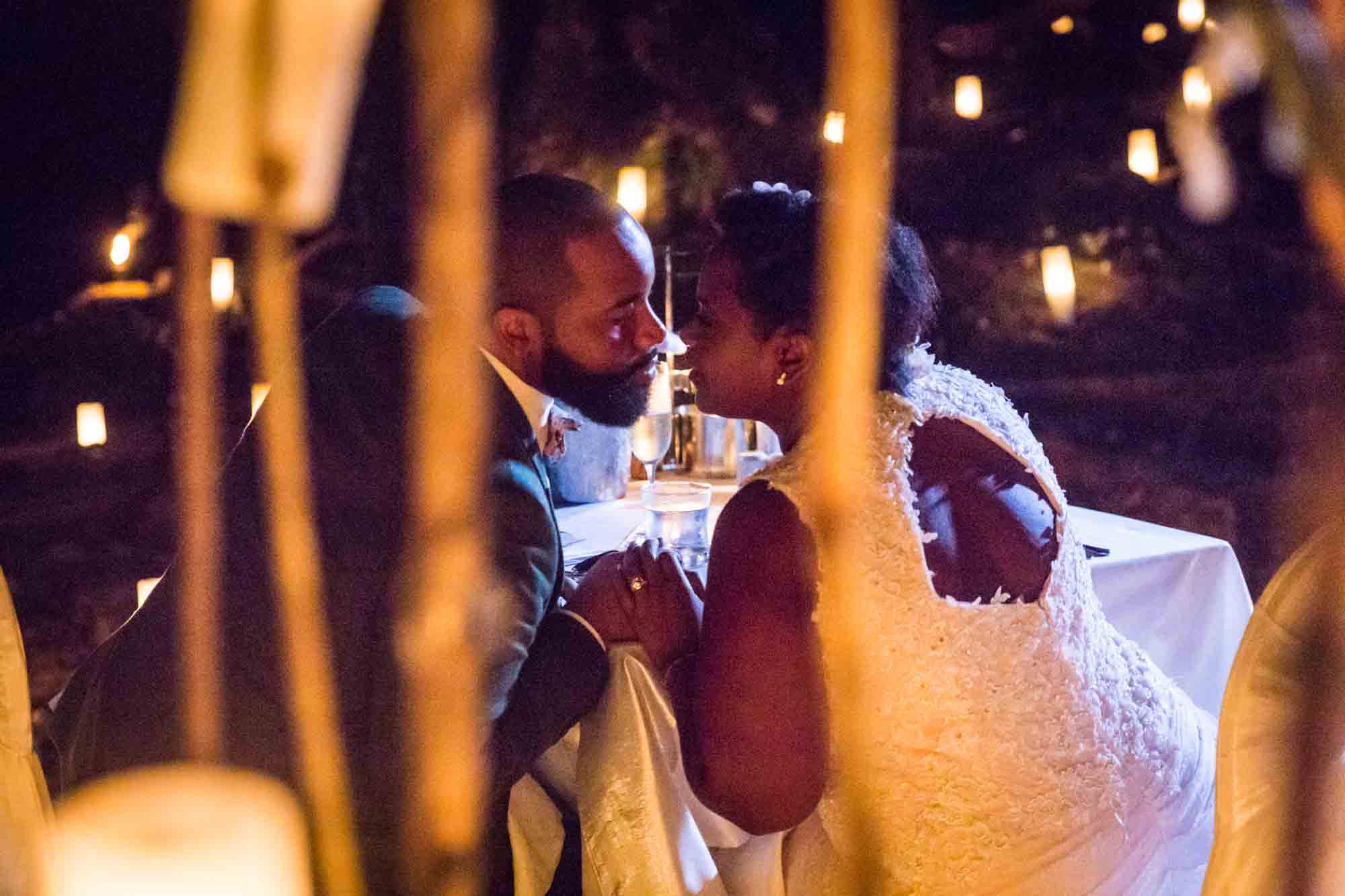 Bride and groom kissing by candlelight for an article on destination wedding planning tips