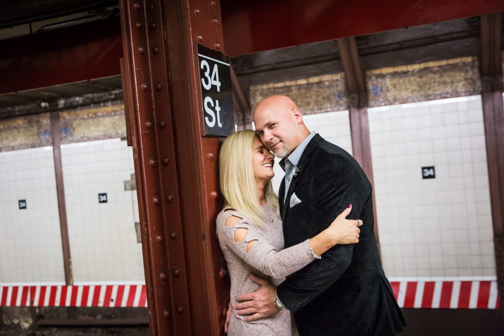 Couple hugging against column on subway platform