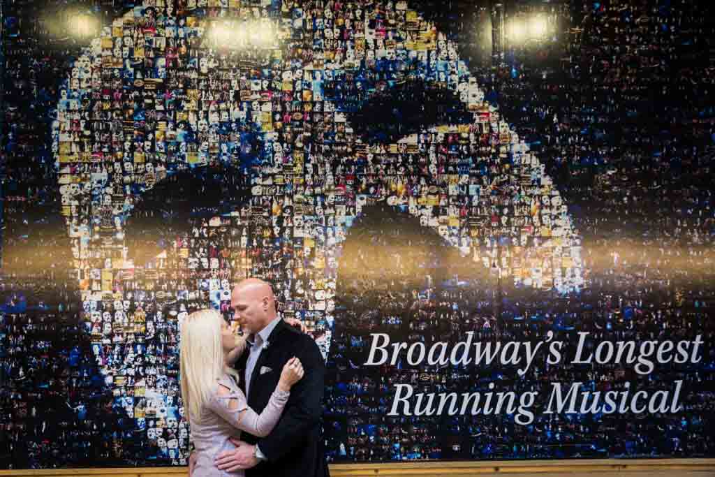 Couple hugging against wall advertisement for Phantom play
