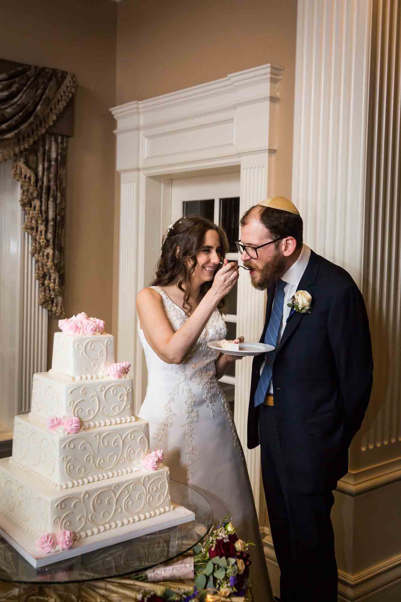 Bride and groom during cake cutting for an article on band vs DJ