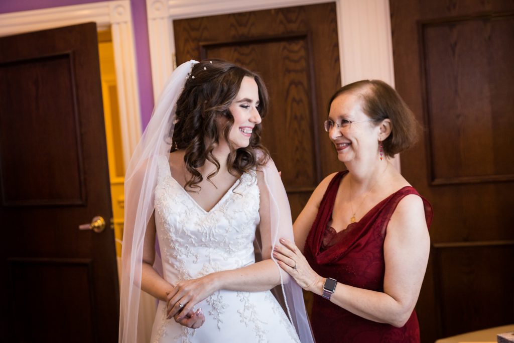 Bride turning around and laughing with her mother