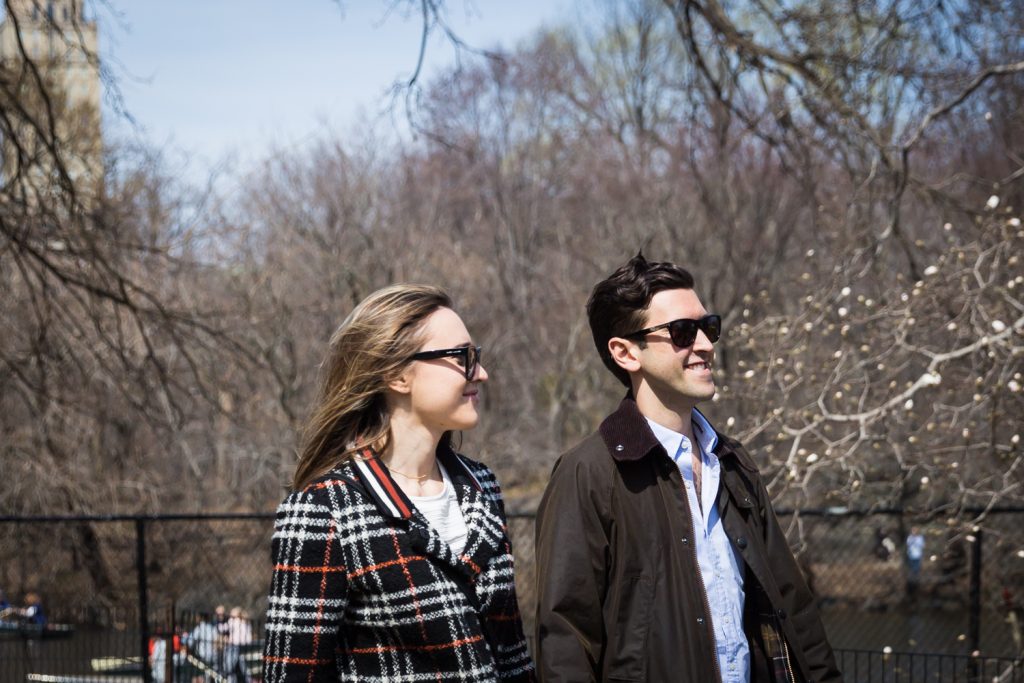 Man and woman wearing sunglasses walking in Central Park for article on Central Park Lake proposal tips