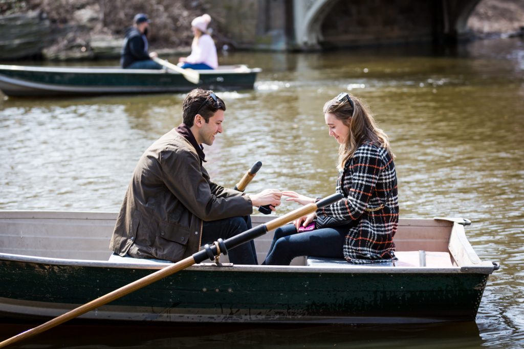 Man in at putting ring on woman's finger for article on Central Park Lake proposal tips