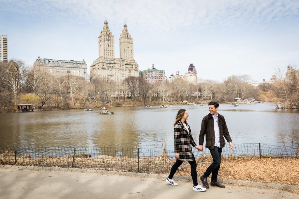 Man and woman walking hand-in-hand past Central Park Lake for an article on Central Park Lake proposal tips