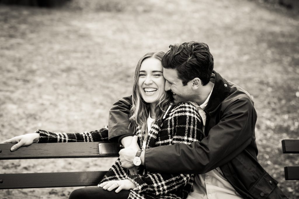 Black and white portrait of couple hugging on bench