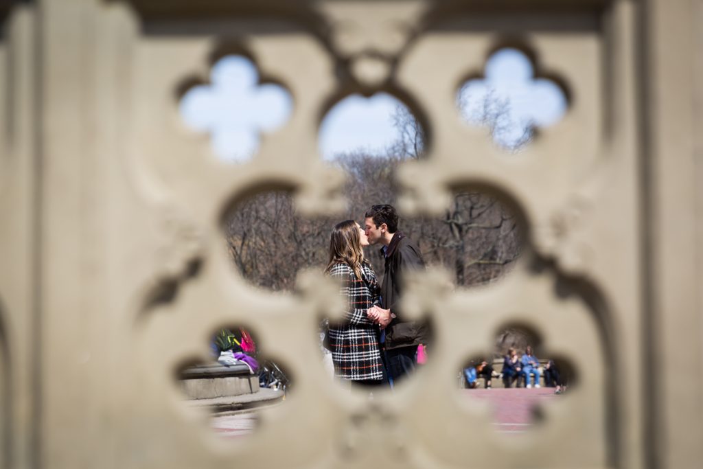View of couple kissing through fence in Bethesda Fountain