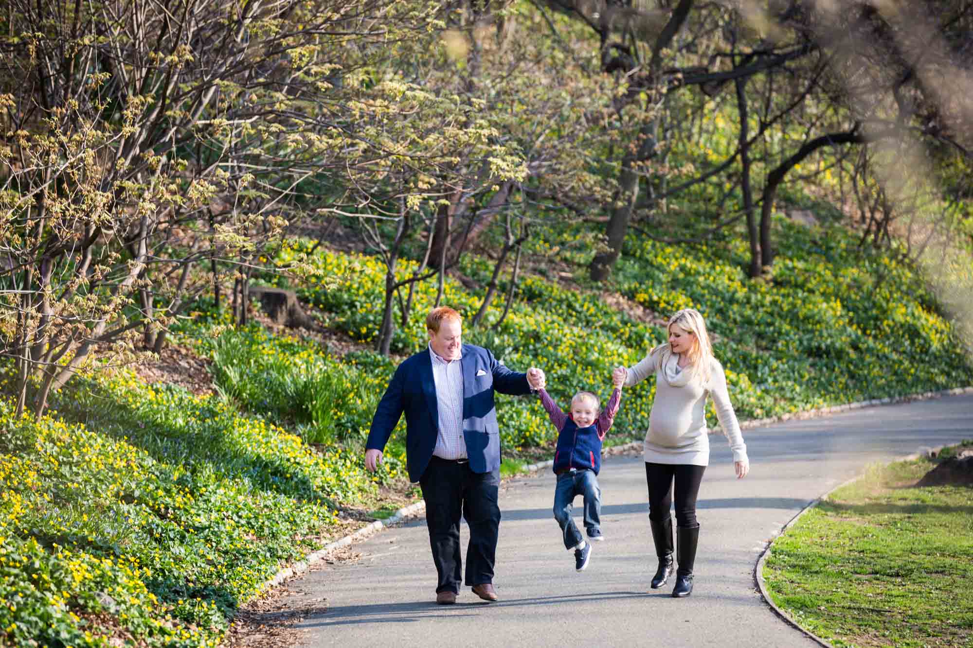 Family walking down pathway in Central Park for an article on the best family portrait poses