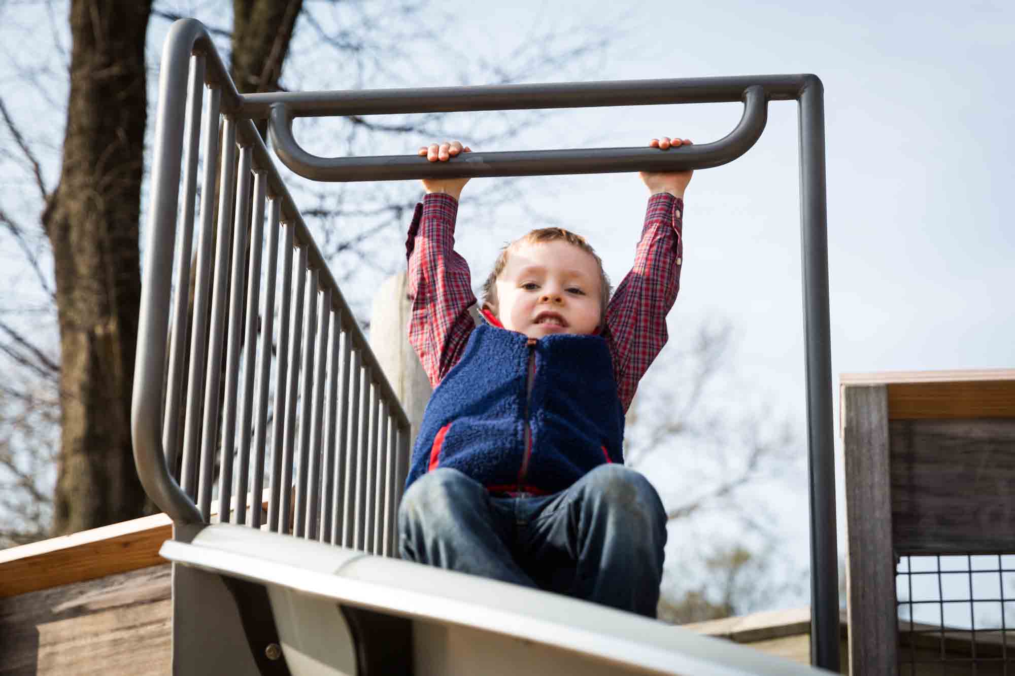 Child on playground equipment for an article on the best family portrait poses