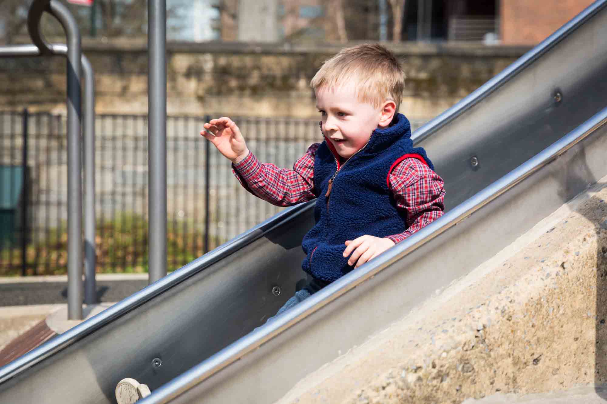 Little boy on slide for an article on the best family portrait poses