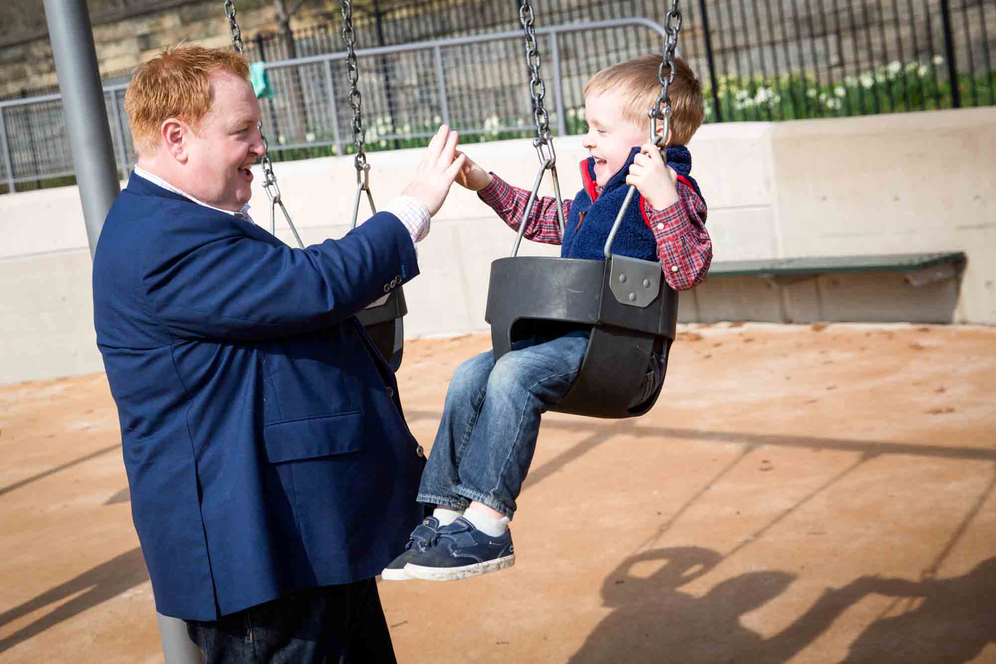 Father with son on swing for an article on the best family portrait poses