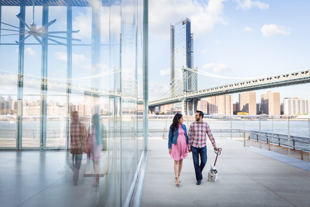 Pregnant woman and husband reflected in glass wall of Jane's Carousel for article on maternity portrait tips