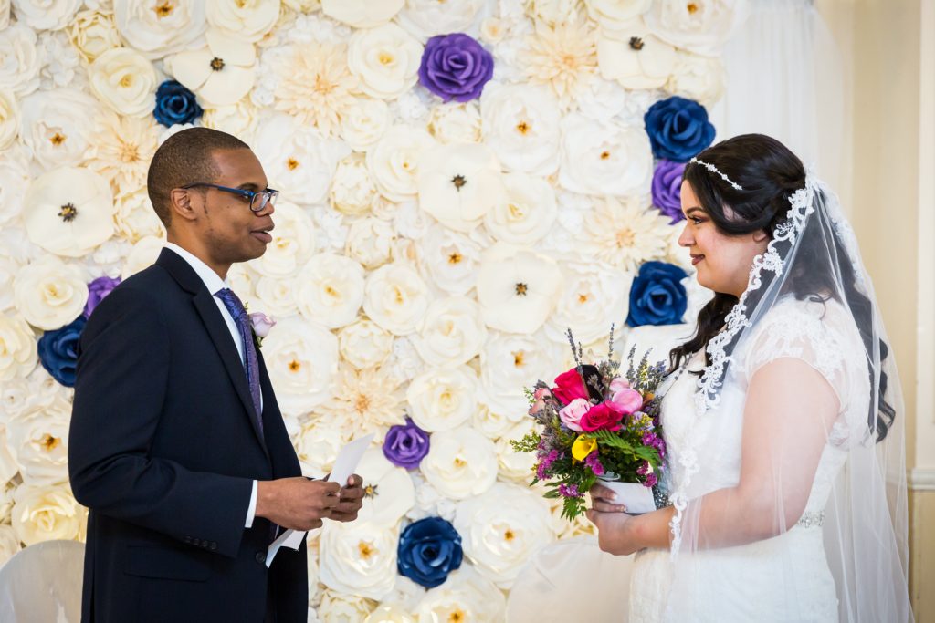 Bride and groom saying vows during wedding ceremony for an article on wedding photography timeline tips
