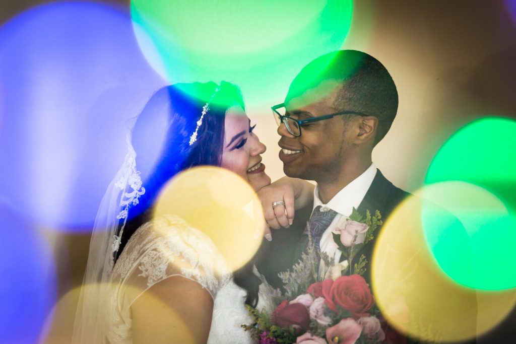 Portrait of bride and groom seen through colored lights