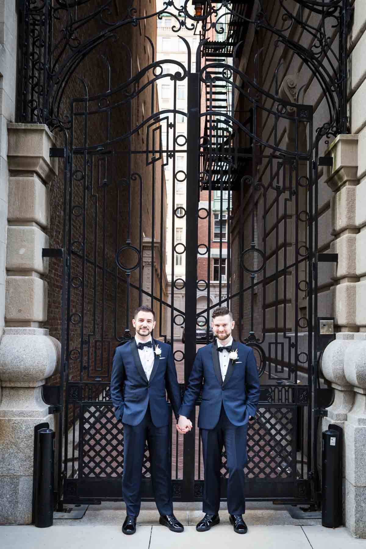 Two grooms in front of gate The Dakota apartment building