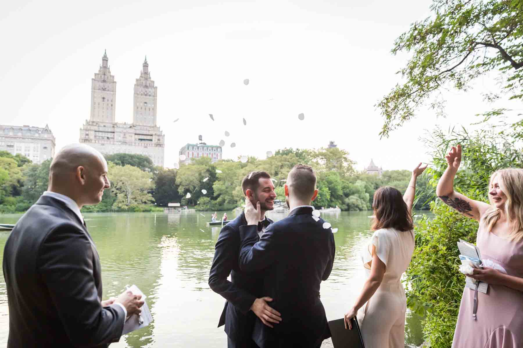 Wedding party throwing rose petals for an article entitled, ‘Do you need a permit to get married in Central Park?’