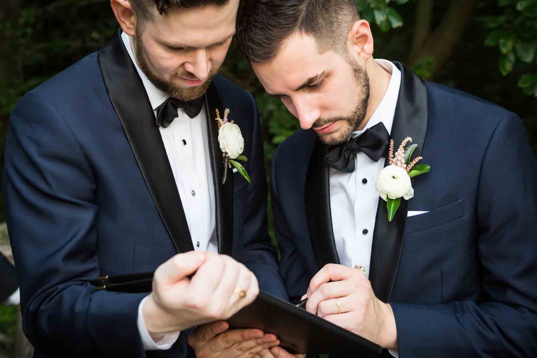 Two grooms signing marriage license for an article entitled, ‘Do you need a permit to get married in Central Park?’
