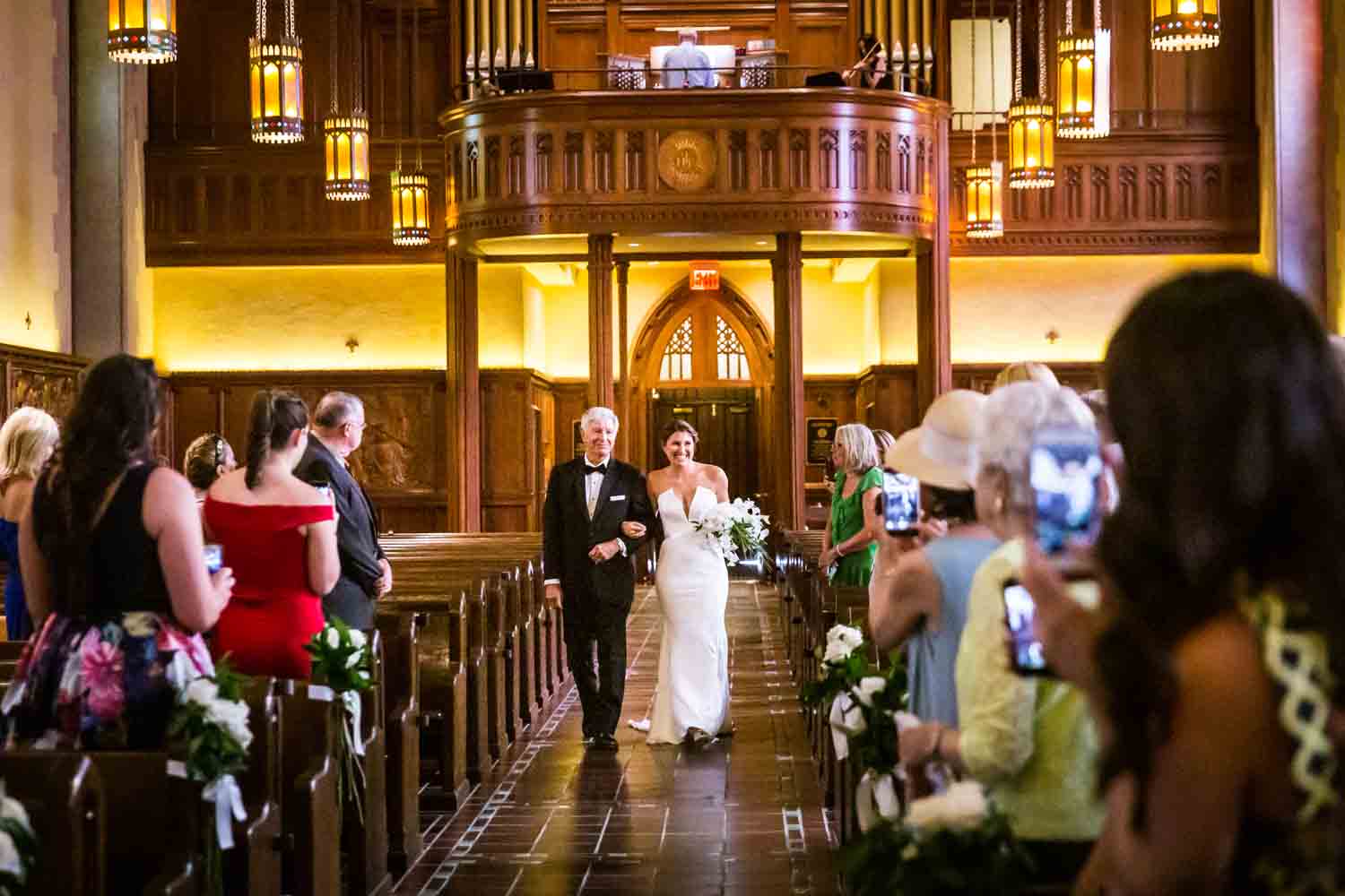 Bride and father walking down aisle for an article on Bronx Zoo wedding venue updates