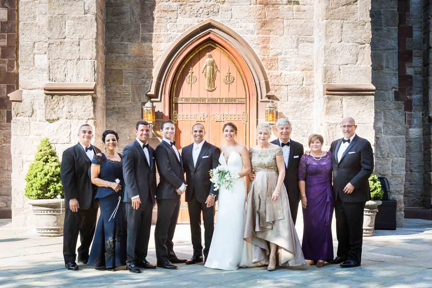 Family wedding portrait outside Fordham University Church for an article on Bronx Zoo wedding venue updates