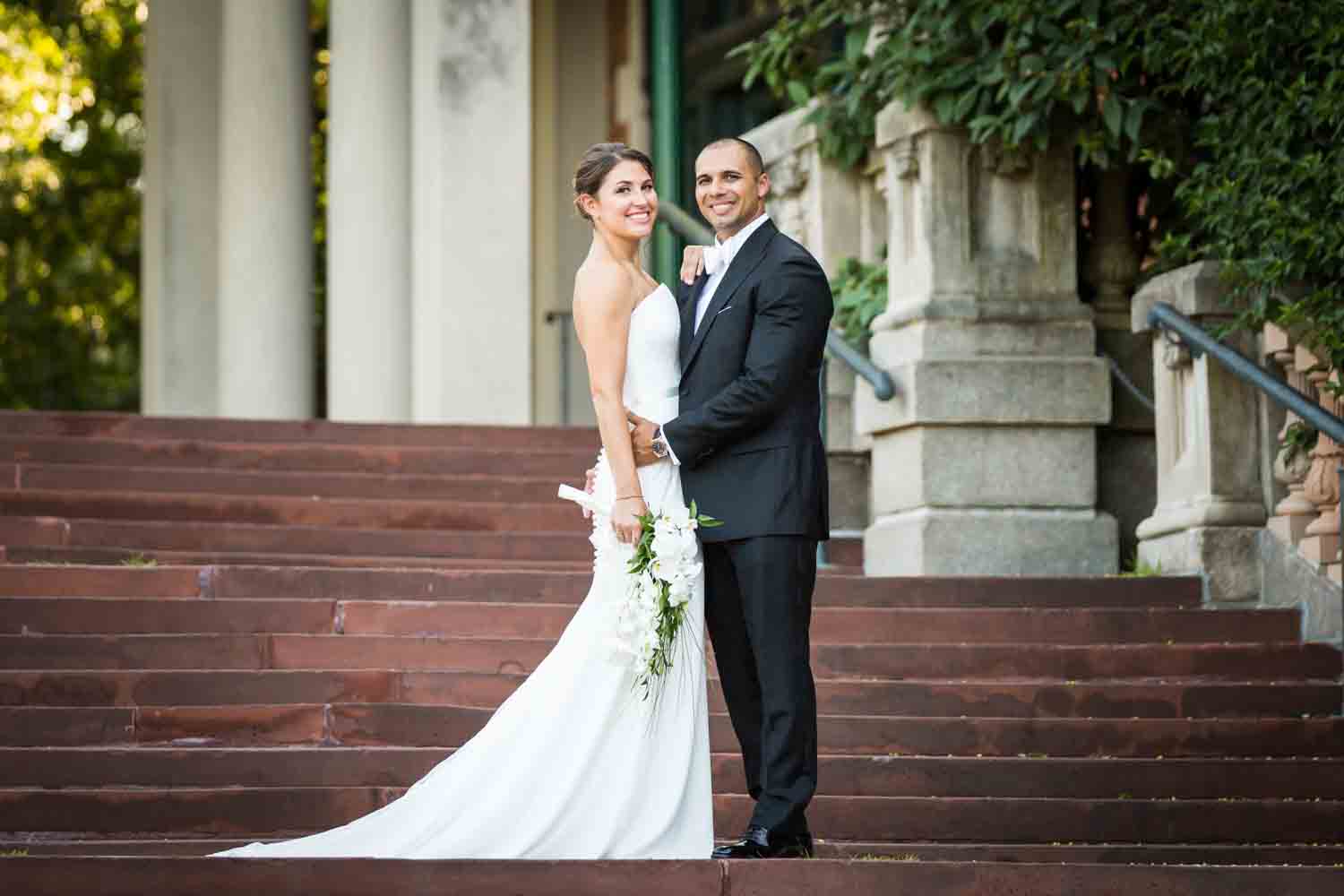 Bride and groom on Bronx Zoo entrance staircase for an article on Bronx Zoo wedding venue updates