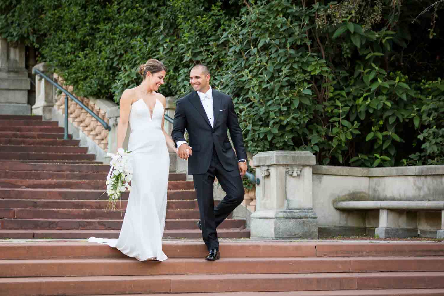 Bride and groom walking down Bronx Zoo entrance staircase for an article on Bronx Zoo wedding venue updates