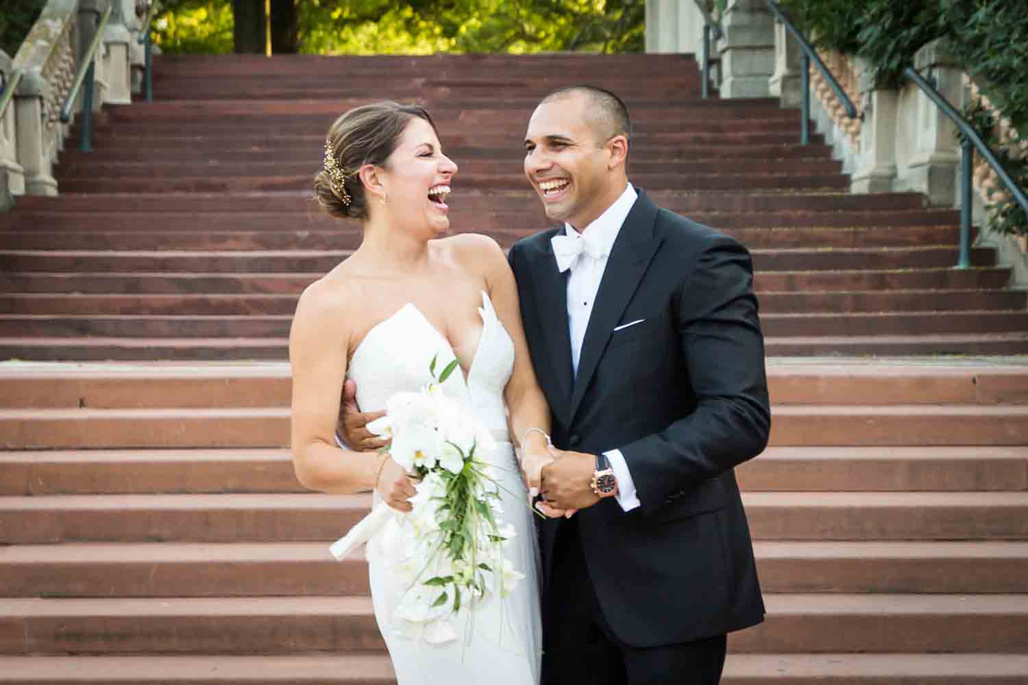 Bride and groom on Bronx Zoo entrance staircase for an article on Bronx Zoo wedding venue updates