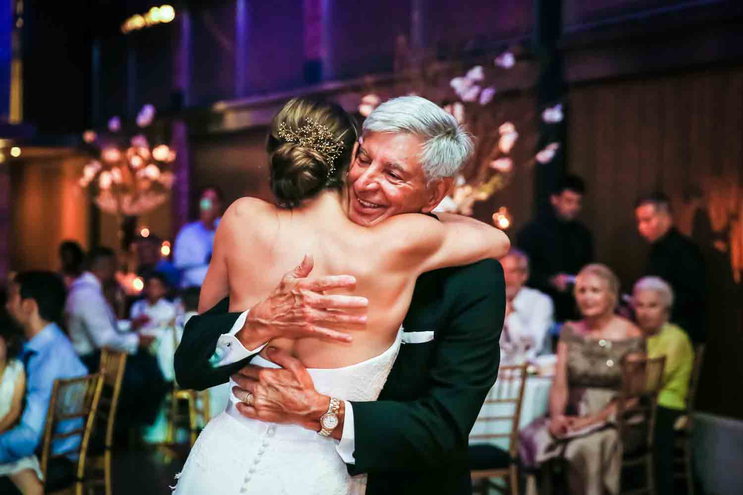 Bride and father hugging for an article on Bronx Zoo wedding venue updates