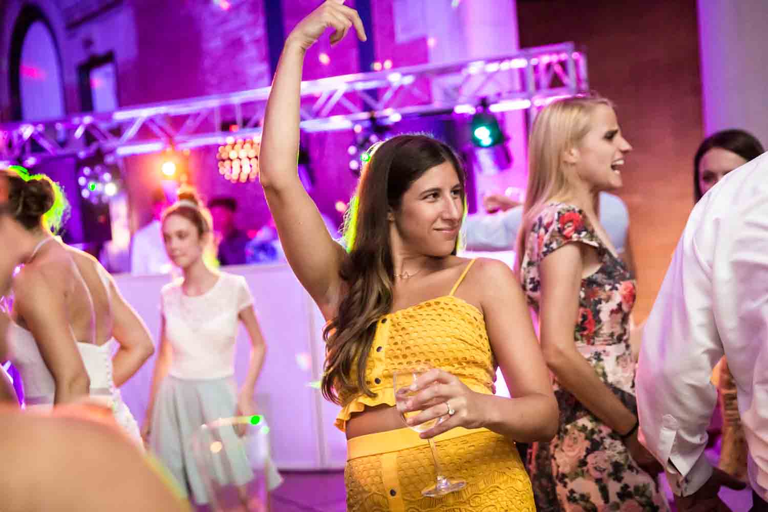 Guest in yellow dress dancing for an article on Bronx Zoo wedding venue updates