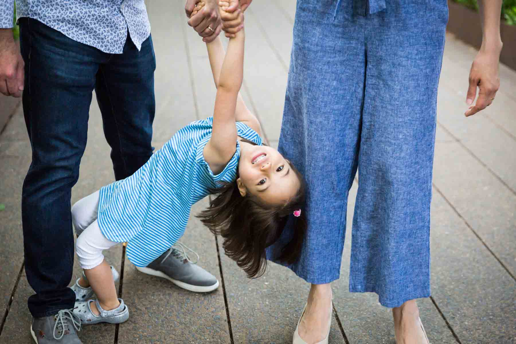 Little girl holding parents' hands for an article on High Line family portrait tips