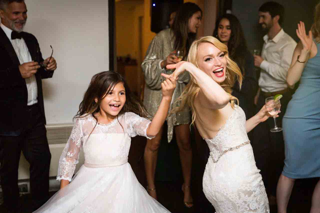 Bride and little girl dancing at a Central Park Conservatory Garden wedding