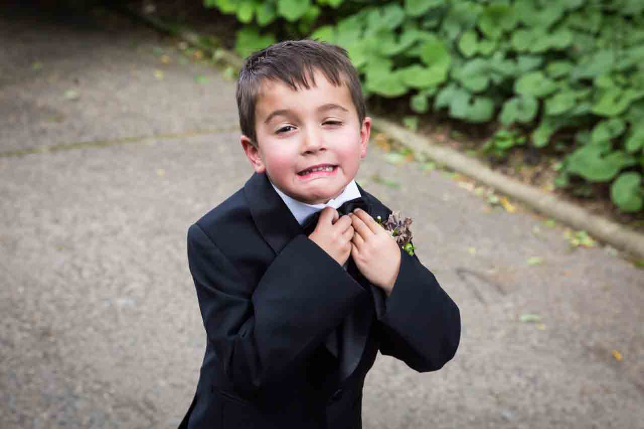 Ring bearer adjusting tie at a Central Park Conservatory Garden wedding