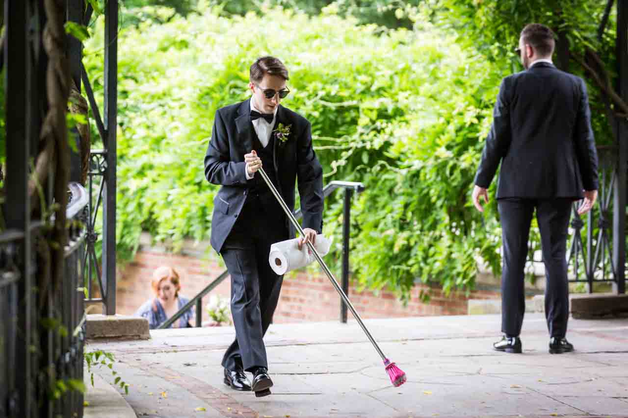 Groomsmen sweeping floor at a Central Park Conservatory Garden wedding