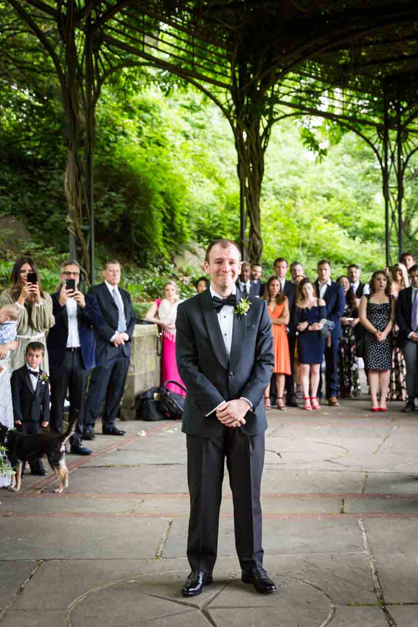 Groom waiting for bride at end of aisle at a Central Park Conservatory Garden wedding