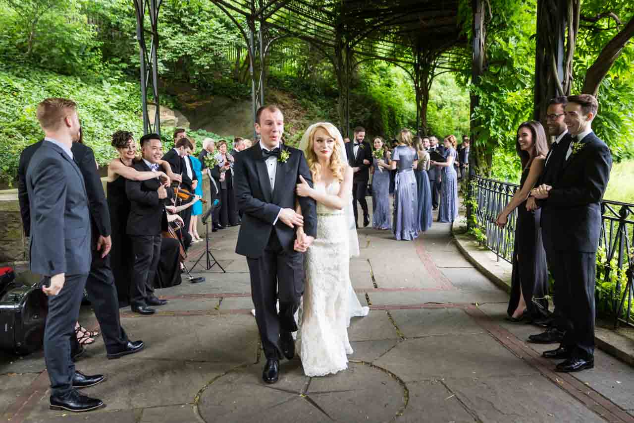Bride and groom walking aisle after ceremony at a Central Park Conservatory Garden wedding