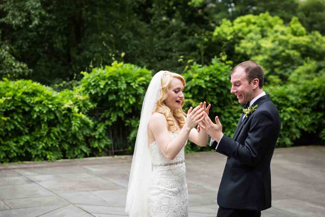 Bride and groom looking at rings at a Central Park Conservatory Garden wedding