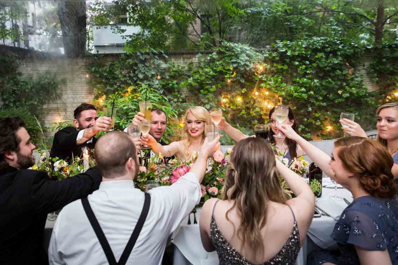 Bridal party toasting glasses at a Central Park Conservatory Garden wedding