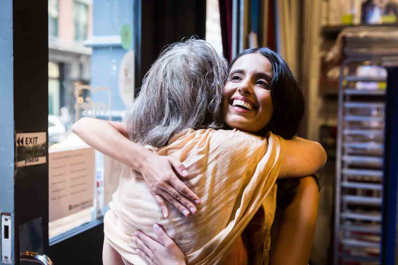 Bride hugging mother-in-law for an article on non-floral centerpiece ideas